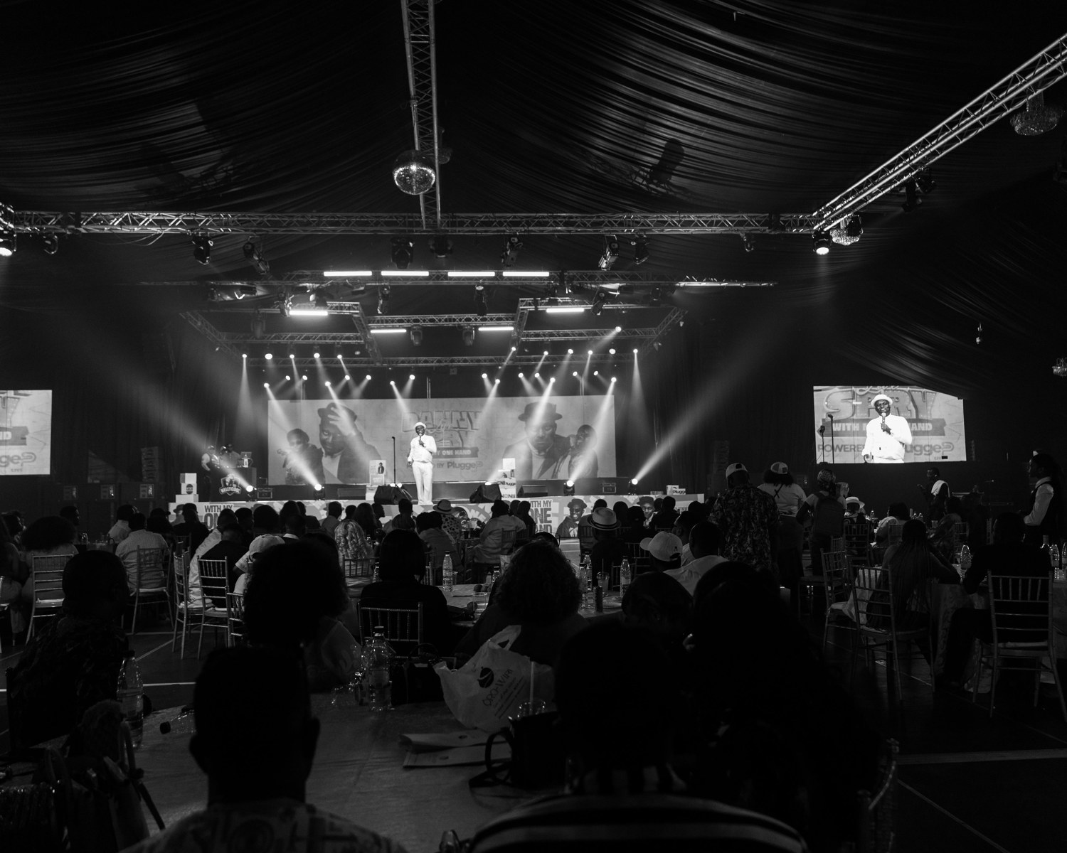 A full room and illuminated stage at the Danny Spry comedy special